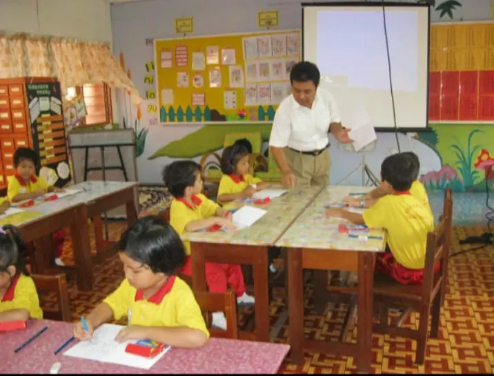 Guru mengajar siswa TK di dalam kelas